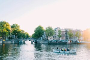Elektrisch rondvaartbootje op een Amsterdamse gracht bij zonsondergang